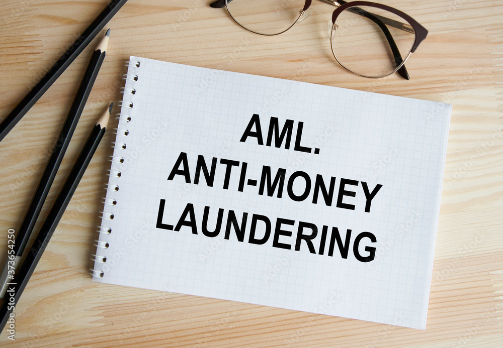 The inscription in the Anti-money laundering- AML notebook, a pen and glasses next to it. The inscription in the Anti-money laundering- AML notebook, a pen and glasses next to it.