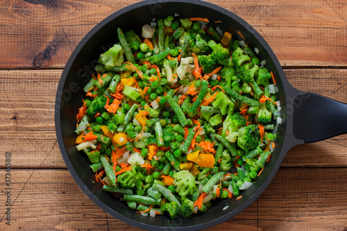 Cooking frozen vegetables rice step by step, step 3 - adding chopped frozen vegetables, top view, horizontal