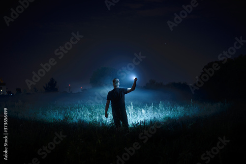 Person with flashlight at night © seligaa