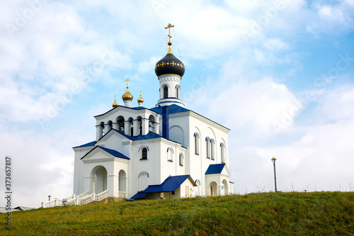 Orthodox church of white and blue in the afternoon. A church in Myadzel in Belarus.