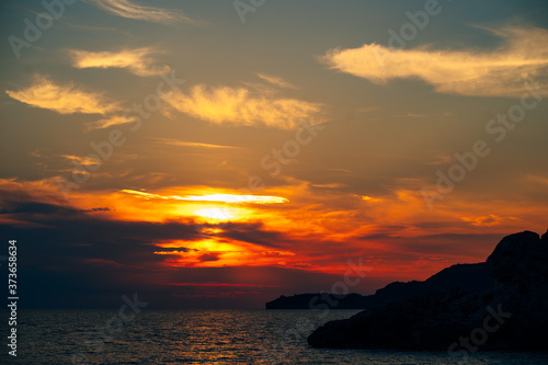 Fiery red sunset sky over the sea. © Nadtochiy