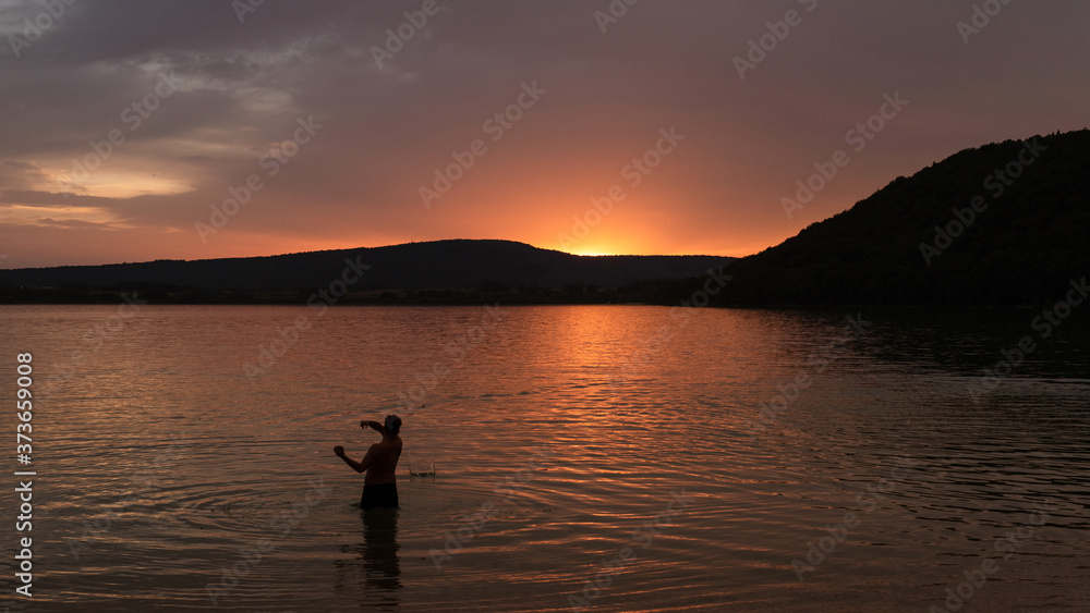 Man throwing stones in the Chalain lake, France 