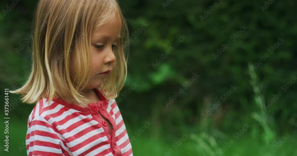 Little preschooler standing in garden in summer Little preschooler standing in garden in summer