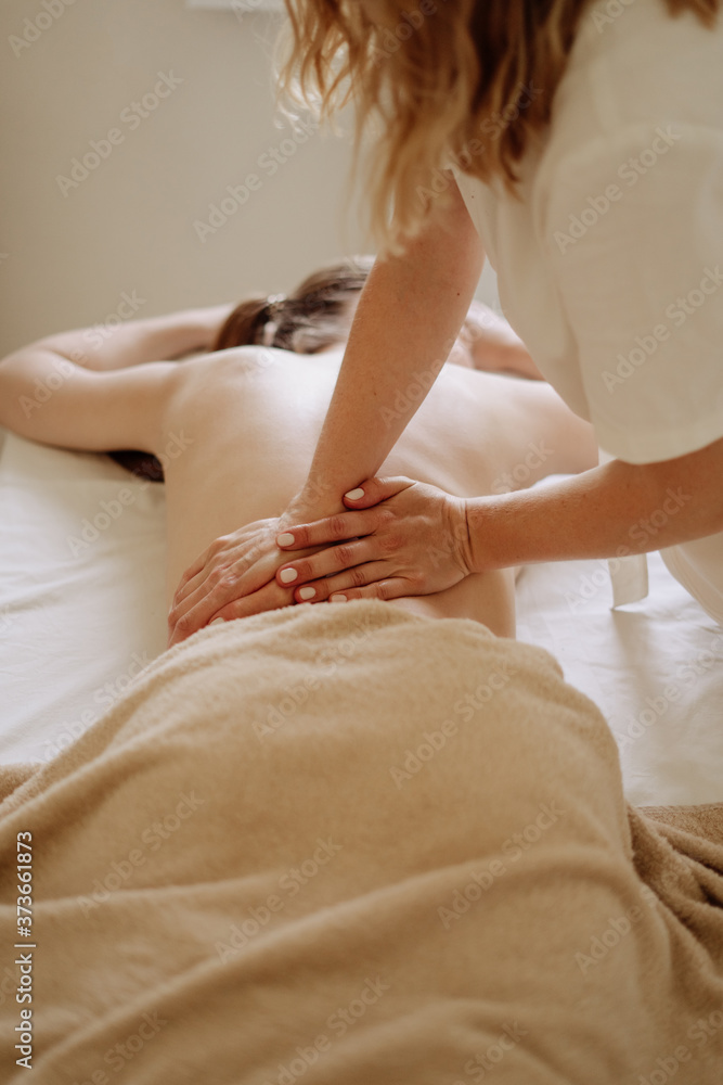 Masseur Massaging Client Spine in Spa Cabinet Masseur Massaging Client Spine in Spa Cabinet