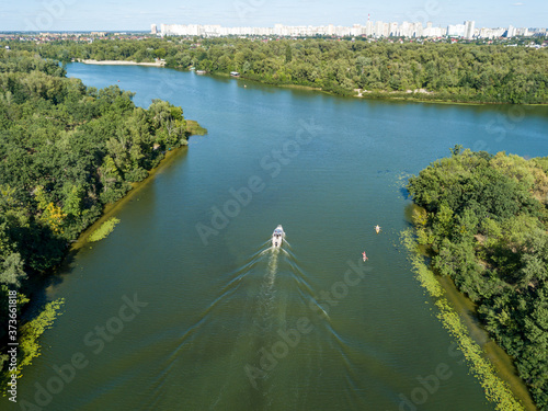 Motor boat in the Dnipro river. Sunny clear summer day. Aerial drone view.