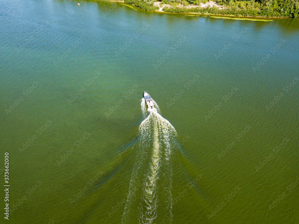 Motor boat in the Dnipro river. Sunny clear summer day. Aerial drone view. Motor boat in the Dnipro river. Sunny clear summer day. Aerial drone view.