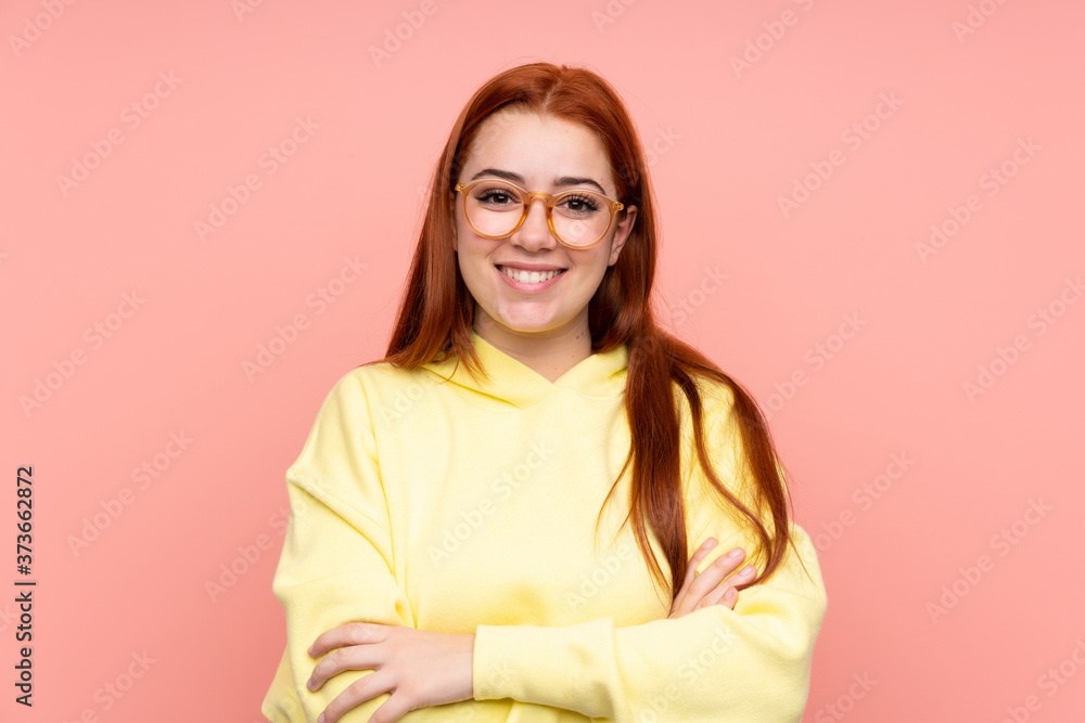 Redhead teenager girl over isolated pink background with glasses and happy Redhead teenager girl over isolated pink background with glasses and happy