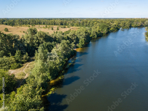 Green bank of the Dnieper river on a summer sunny day. Aerial drone view.