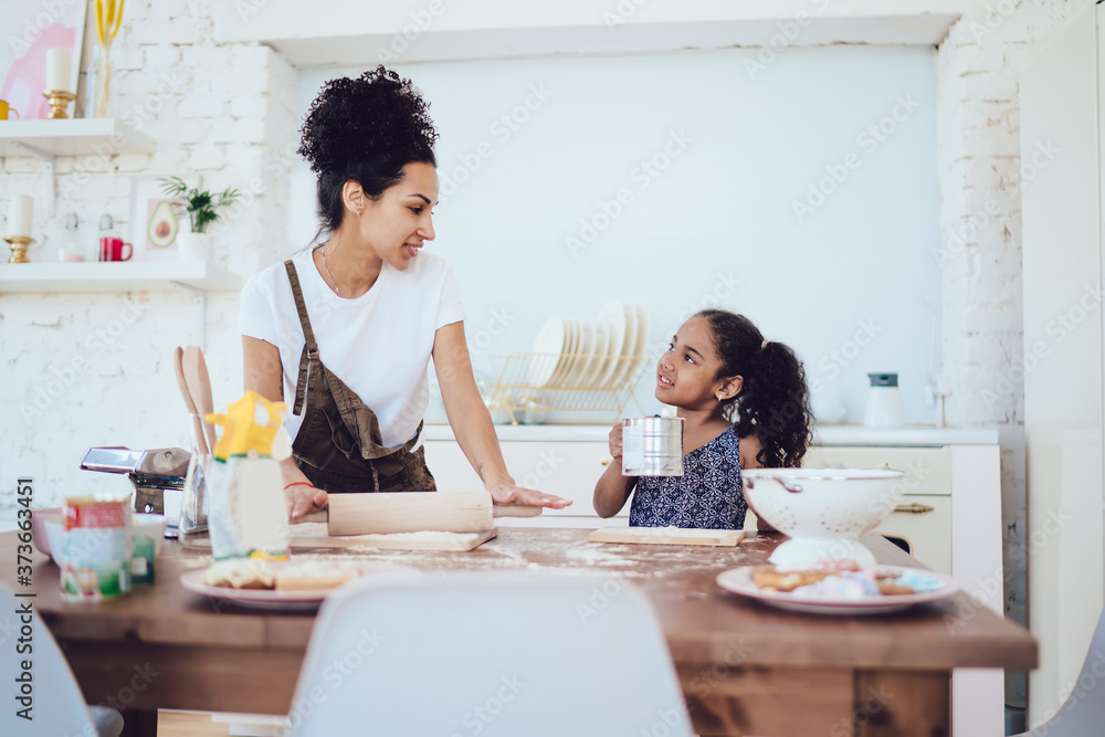 Young mother cooking with daughter in kitchen Young mother cooking with daughter in kitchen