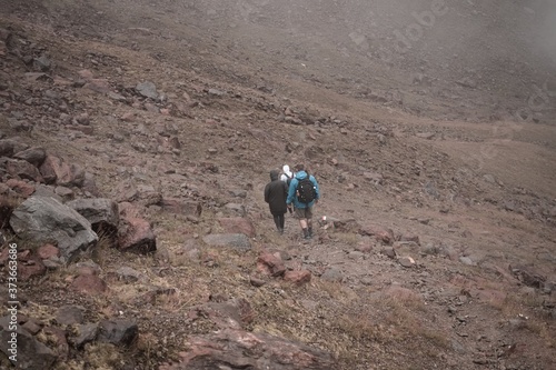 Three people are climbing a mountain on a foggy day on the italian Alps (Peio, Trentino - Alto Adige, Italy, Europe) photo