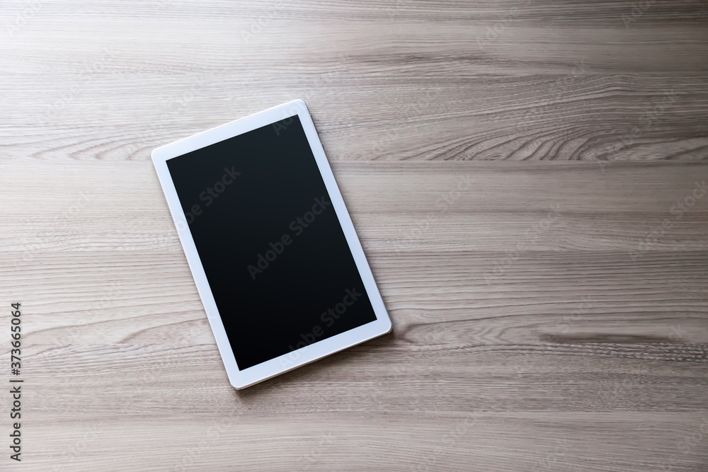 White tablet pc with empty screen on wood background White tablet pc with empty screen on wood background