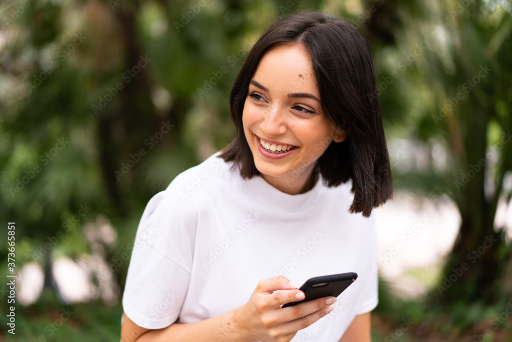 Young caucasian woman using a phone at outdoors Young caucasian woman using a phone at outdoors