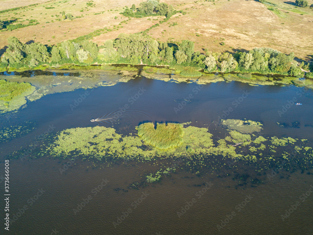 Green bank of the Dnieper river on a summer sunny day. Aerial drone view.