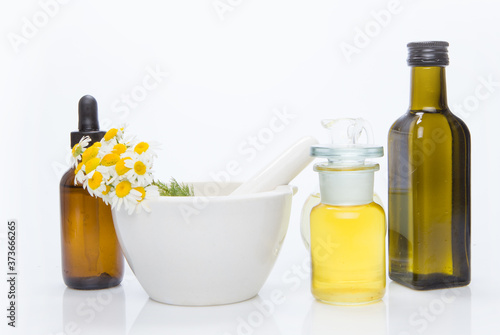 Healing herbs with mortar and bottle of essential oil.