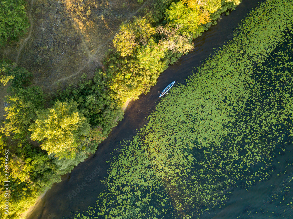 Kayak boat in the green water of the Dnieper river. Aerial drone view.