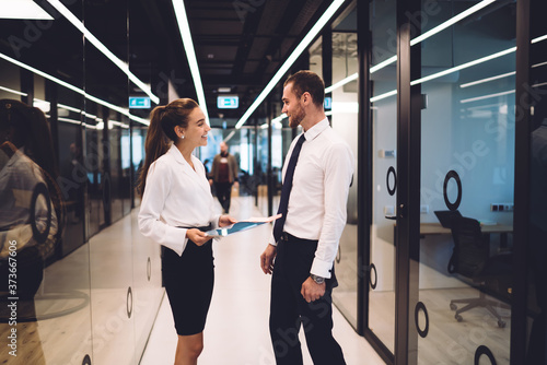 Cheerful coworkers talking at modern workplace