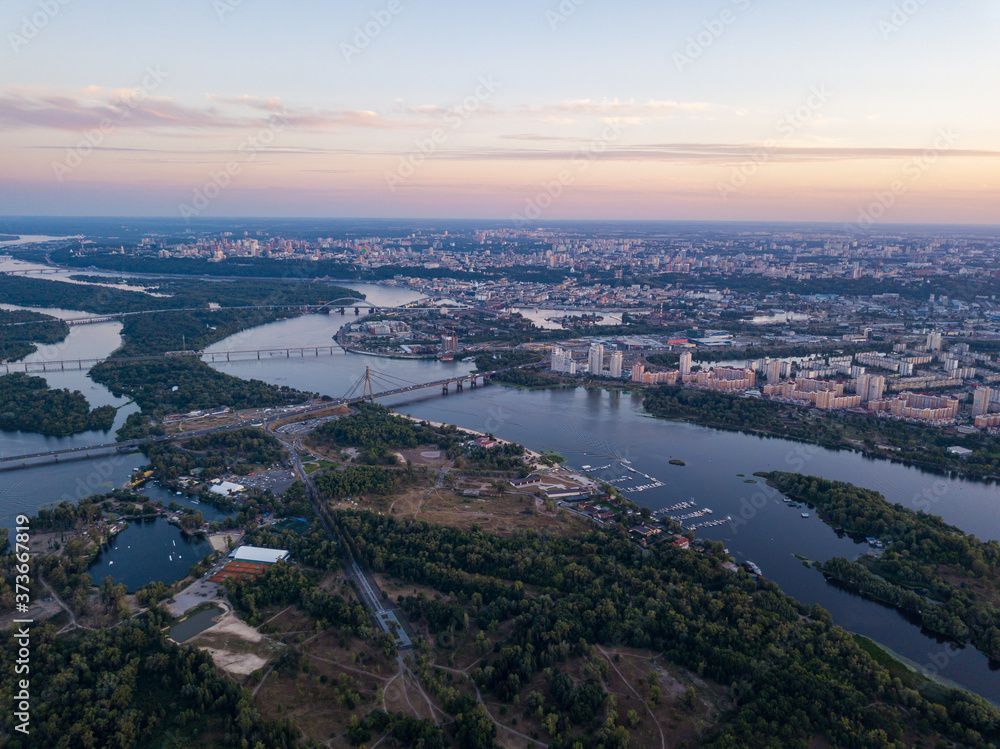Fototapeta premium Aerial view. Dnieper river and Kiev city at dusk.