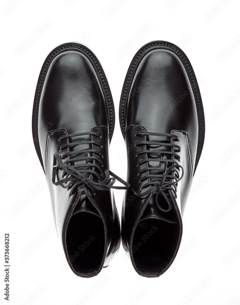 Classic black plain toe boots made of durable glossy leather with a small lace-up heel, isolated on a white background with a shadow. Top view.