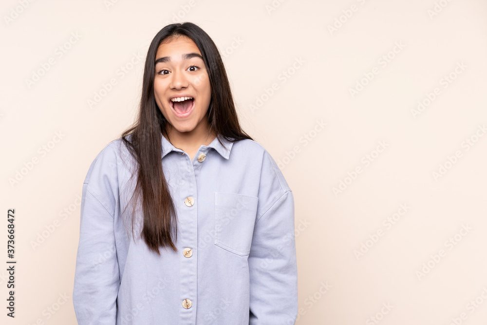 Young Indian woman isolated on beige background with surprise facial expression Young Indian woman isolated on beige background with surprise facial expression