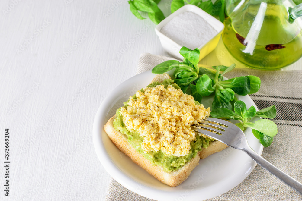 Toast of avocado and egg, lettuce on the plate. Ketogenic healthy diet breakfast. Toast of avocado and egg, lettuce on the plate. Ketogenic healthy diet breakfast.