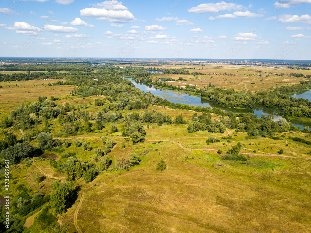 Aerial drone view. Green meadows by the river.