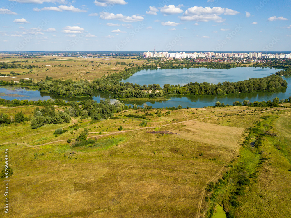 Aerial drone view. Green meadows by the river.