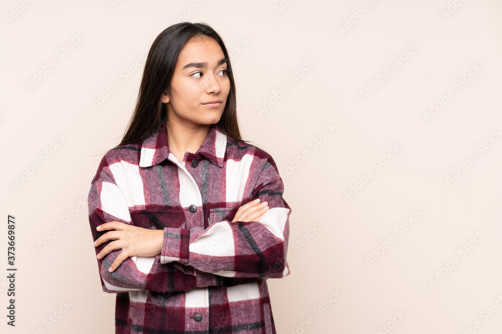Young Indian woman isolated on beige background keeping the arms crossed Young Indian woman isolated on beige background keeping the arms crossed