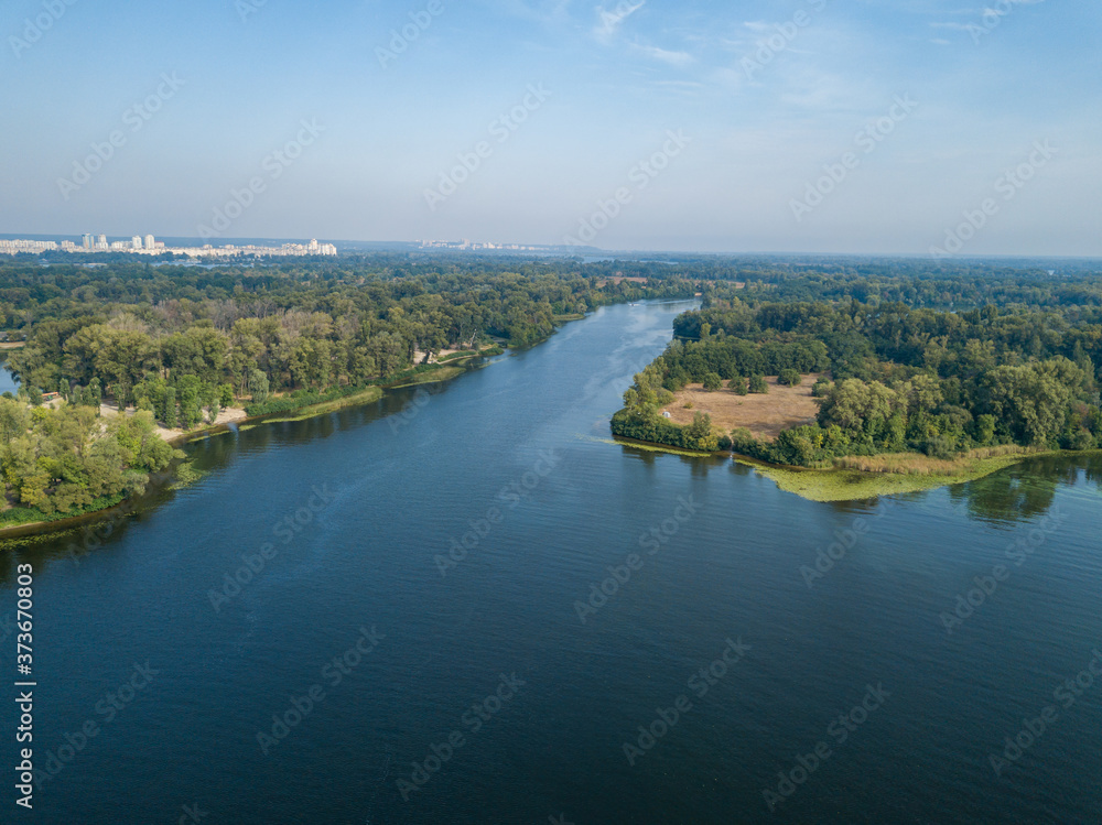 Aerial drone view. Green bank of the Dnieper river on a summer sunny day. Aerial drone view. Green bank of the Dnieper river on a summer sunny day.
