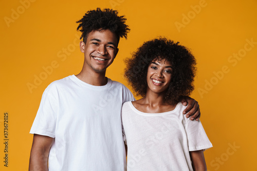 Image of happy african american couple hugging and smiling at camera