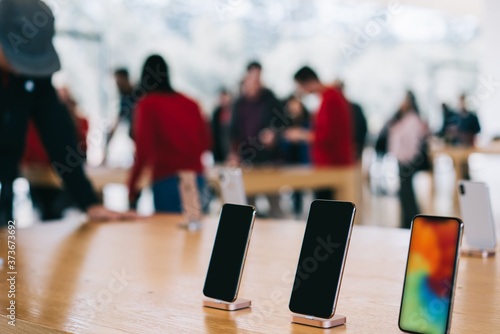 Cupertino , California / USA - November 17, 2018, Apple Park Visitor Center. Modern smartphone with big screen, different models of Iphone, blurred customers on background