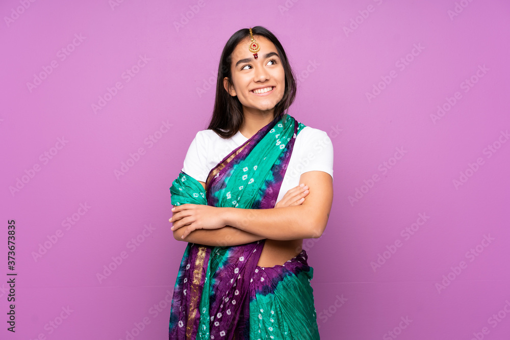 Young Indian woman with sari over isolated background looking up while smiling Young Indian woman with sari over isolated background looking up while smiling