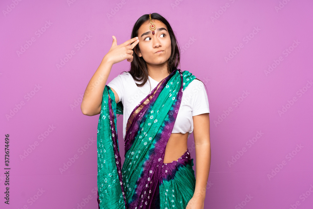 Young Indian woman with sari over isolated background with problems making suicide gesture