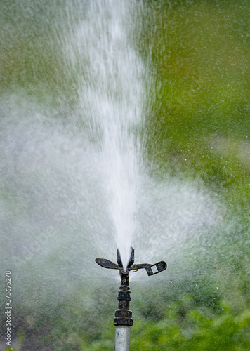 Sprinker irrigation system spraying water on field - close up