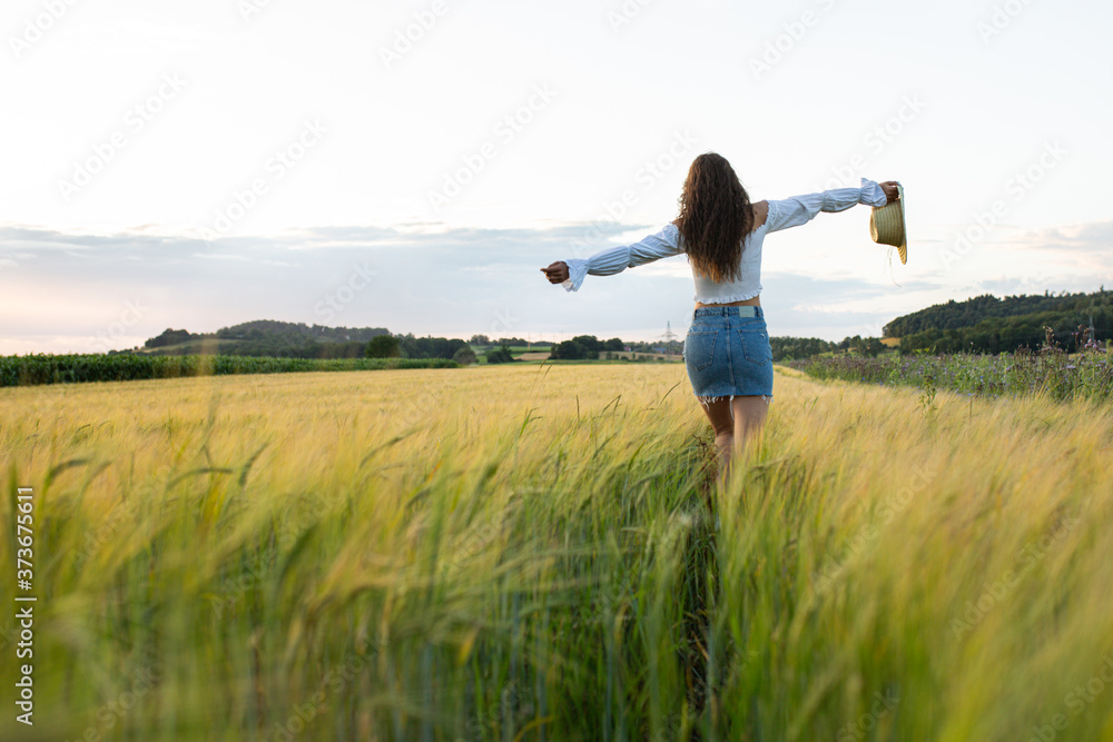 Glückliche junge Frau läuft durch ein Feld Glückliche junge Frau läuft durch ein Feld