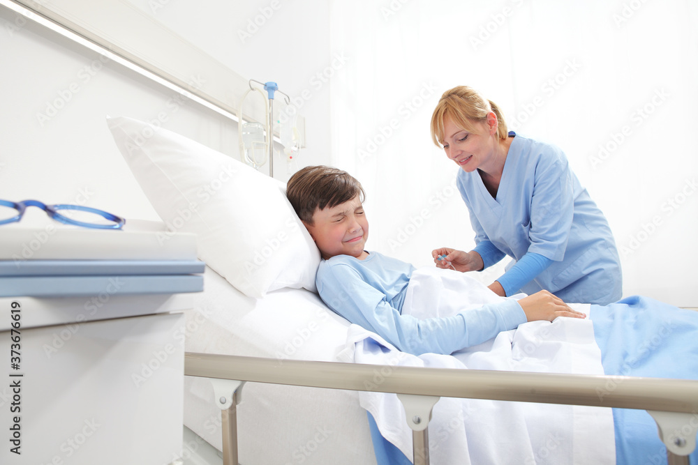 Nurse getting the drip to crying child scared by the needle in hospital room . Nurse getting the drip to crying child scared by the needle in hospital room .