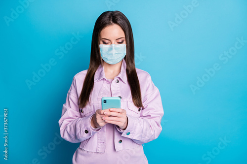 Portrait of her she nice attractive focused girl wearing gauze safety mask using device order app shopping web service stay home delivery isolated bright vivid shine vibrant blue color background