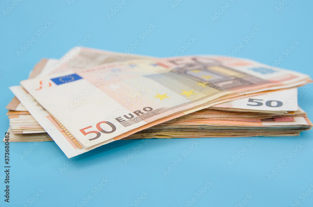 stack with 50 euros on a blue background. stack with 50 euros on a blue background.