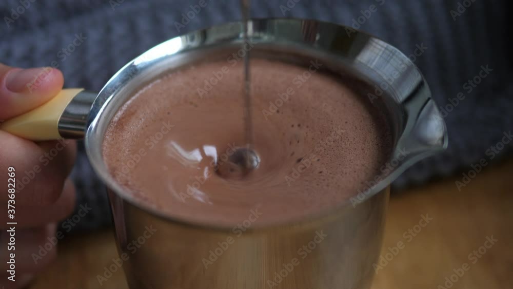 Blending hot chocolate in a steel pitcher. Comforting food concept Blending hot chocolate in a steel pitcher. Comforting food concept
