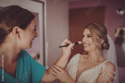 Cuadro en lienzo stylish happy bride dressing in dress, smiling to bridesmaids, at window, rustic wedding morning preparation