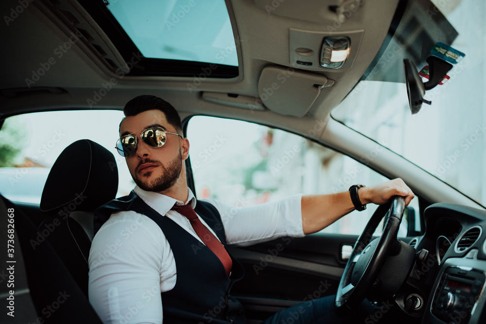 A young businessman in a suit goes to work with car A young businessman in a suit goes to work with car