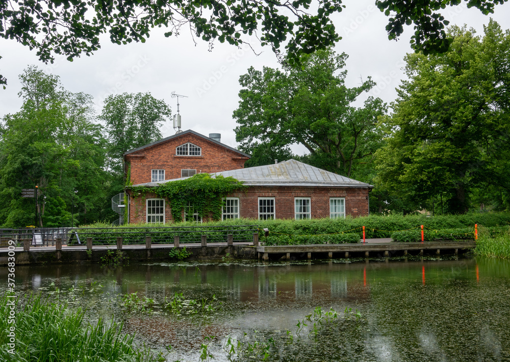 Fototapeta premium A rural road and a small lake in the Fiskars village in the summer time.