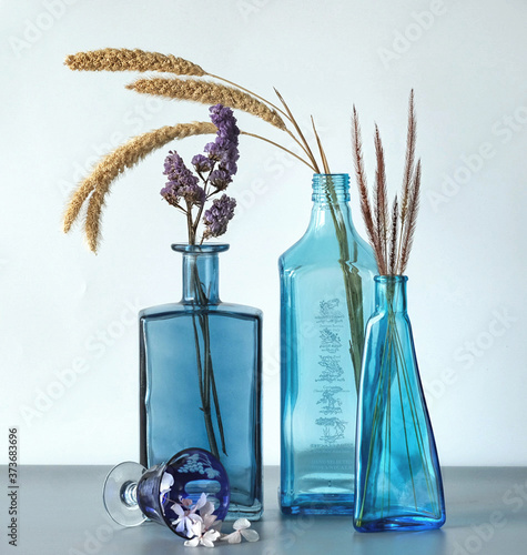 Blue bottles with dry herbs and plants photo