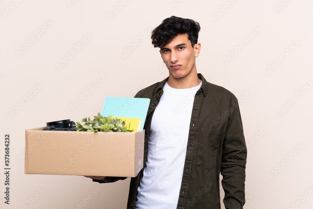 Young Argentinian man moving in new home over isolated background with sad expression Young Argentinian man moving in new home over isolated background with sad expression