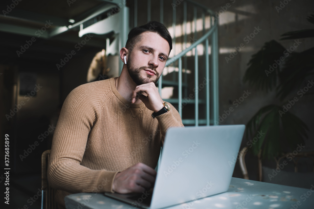 Delighted guy with laptop looking at camera Delighted guy with laptop looking at camera