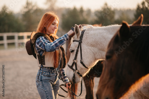 Young woman farmer combing a horse at the ranch. Close-up.