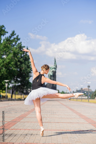 Young and beautiful ballerina posing on the street