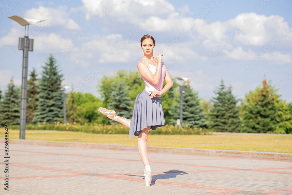 Young and beautiful ballerina posing on the street