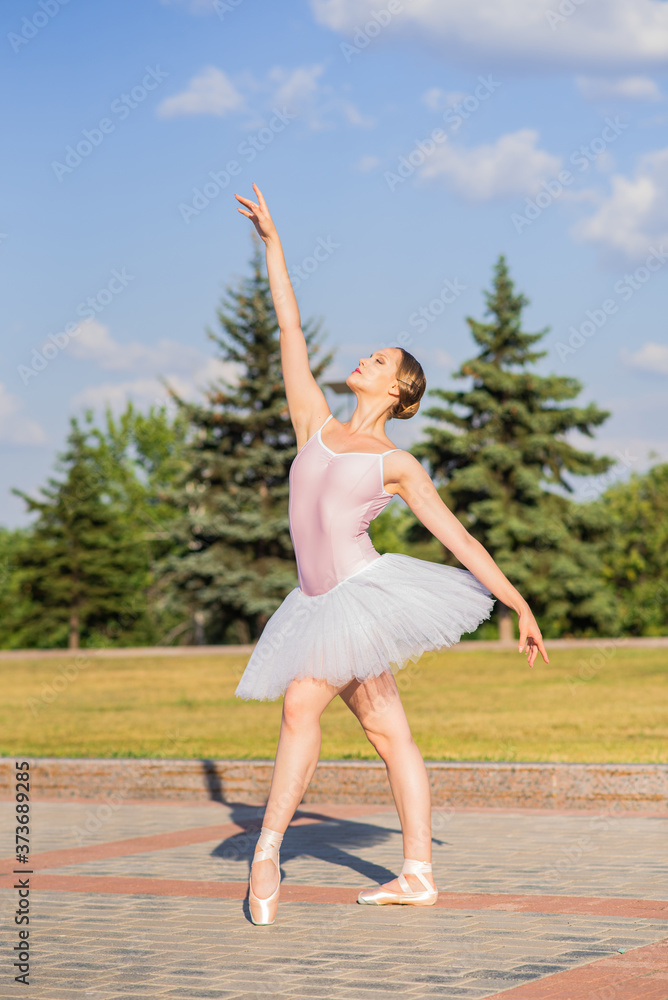 Obraz premium Young and beautiful ballerina posing on the street
