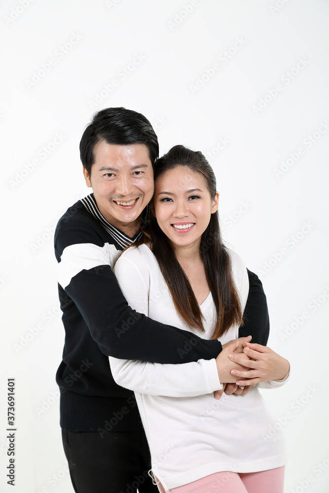 South East Asian young Chinese couple husband wife hung from behind look at camera happy smile hold hands love South East Asian young Chinese couple husband wife hung from behind look at camera happy smile hold hands love