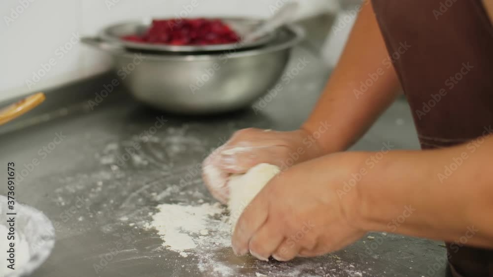 cooking. close-up. on the kitchen table, sprinkled with flour, female hands knead the dough. health food and safety concept. reopening canteen. volunteering and charity cooking. close-up. on the kitchen table, sprinkled with flour, female hands knead the dough. health food and safety concept. reopening canteen. volunteering and charity